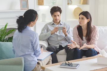 Desperate woman talking to psychiatrist during couple counseling session