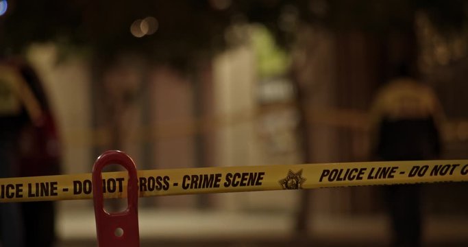 Police tape across a street at an urban crime scene