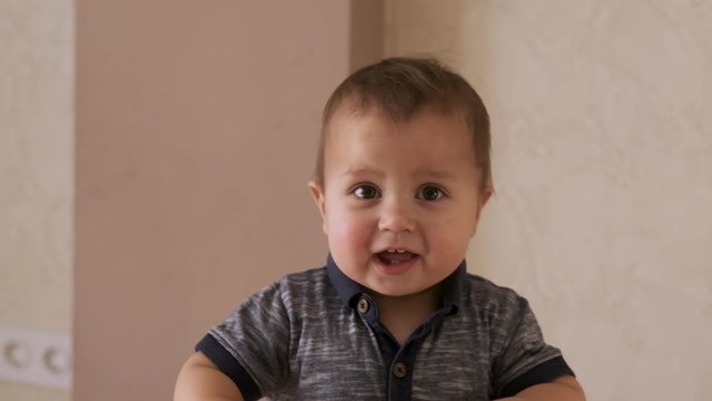 Cute baby smiling and looking at camera close up on the face.