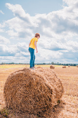 Naklejka na ściany i meble Childhood - caucasian happy child boy in jeans and yellow t-shirt playing on sunny field