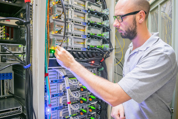 The system administrator works in the data center. Portrait of a technician working with computer...