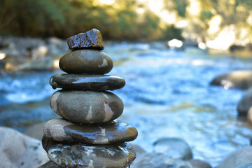stack of stones on sea background of blue sky and clouds