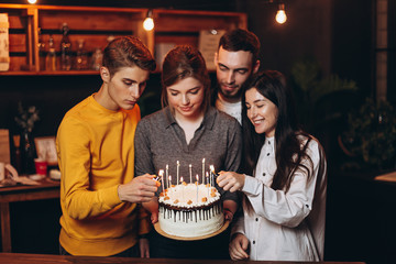 Young people congratulating a pretty woman with birthday at home