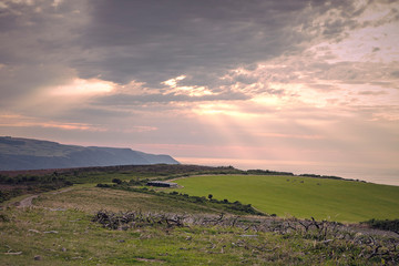 Scenic Somerset coast. Countryside, English landscape. Summer sunset. View on Bristol Channel, green meadows, cloudy sky. Seaside