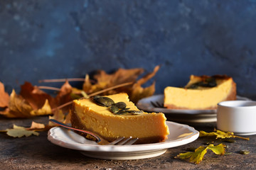 Homemade classic pumpkin cheesecake on a blue concrete background. Horizontal focus.