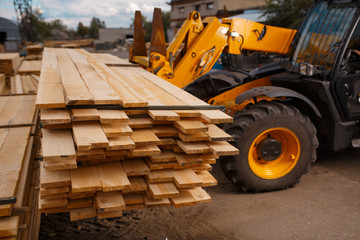 Obraz premium Forklift loads the boards in the lumber yard