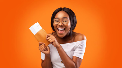 Black Girl Holding Tickets And Passport Over Orange Studio Background