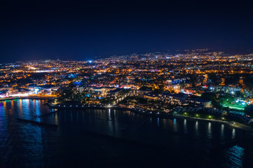 Aerial view of Paphos embankment or promenade at night with reflection of city lights in sea water. Famous Cyprus mediterranean resort.