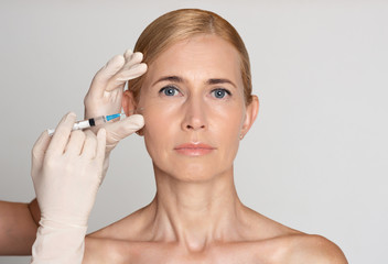 Skin lifting. Middle aged woman getting anti-aging injection