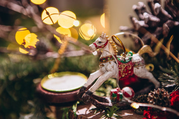 composition with fir branches, cones, Christmas toys and a wax white candle on a Christmas background. Festive Christmas decor with bokeh on the background. New Year, Christmas holiday card.