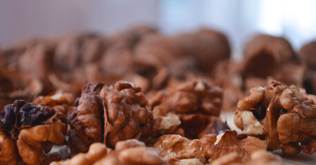 Ripe apples and walnuts on the table. Peeled nuts and shelving from them.