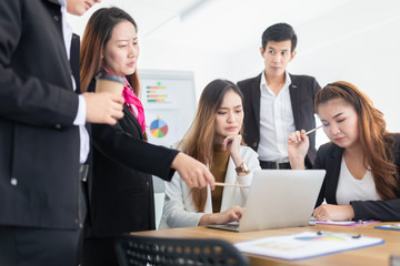 asian officer team feeling stress and seriouse after them project has problem, they looking performance organization result with laptop, development and management organization