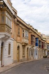 Fototapeta na wymiar Typical street in Malta with colorful traditional balconies