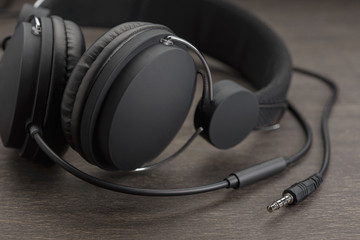 Dark headphones on a wooden background.