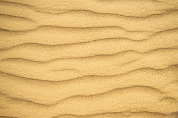 Fototapeta na wymiar Summer sand dune pattern for background. Close-up of patterns in a sand dune with ripples, sand texture