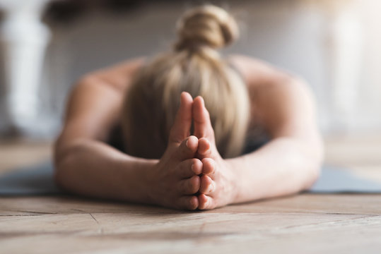 Woman laying face down on yoga mat, meditating