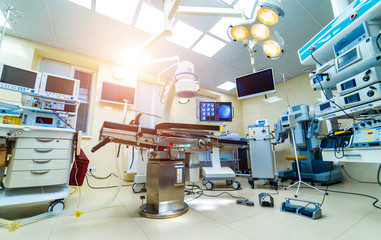 Establishing shot of technologically advanced operating room with no people, ready for surgery. Operating theater with working equipment, lights and computers ready for surgeons.
