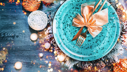 Christmas Holiday Dinner table setting. Tabletop, top view. New Year, Xmas table decoration with blue plate, colorful decor and candles, Served with Gold cutlery on wooden table. Flat lay