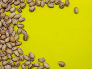 Fototapeta na wymiar Roasted pistachios on a green background