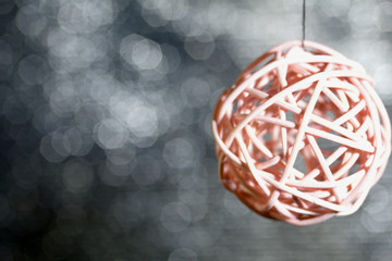 Rattan balls suspended on a thread. Against a bokeh background with white-gray color.