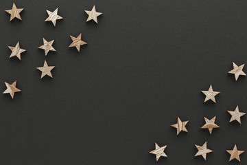 Christmas composition. Wood stars on black background top view background with copy space for your text. Flat lay.