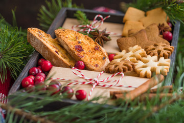 Homemade christmas cookies and wrapped presents with fresh cranberries in a wooden box, close up