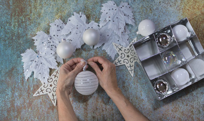 Human hands preparing ornaments for Christmas