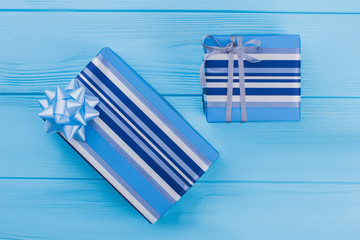Two striped blue gift boxes. Blue wood background. Top view.