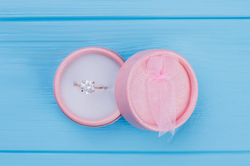 Pink round cosmetic powder for makeup. Blue wood background.