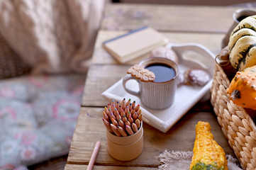 Fototapeta na wymiar Autumn, pumpkins, hot steaming cup of coffee on a wooden table background. Seasonal, morning coffee, sunday relaxing and still life concept. Plans for the day.