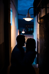 Young romantic married couple stading in the side street under the lantern