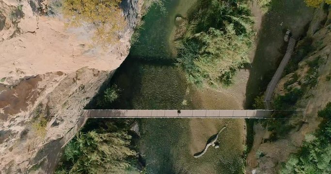 Ascenso vertical de dron encima de puente en acantilado profundo