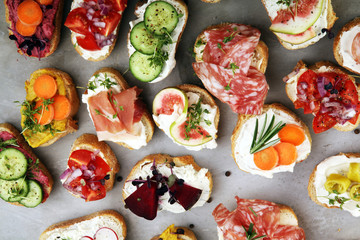 Assorted bruschetta with various toppings. Appetizing bruschetta or brie crostini. Variety of small sandwiches. Mix bruschetta on table