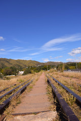 Fototapeta na wymiar train tracks with mountain and blue sky background
