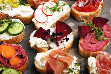 Assorted bruschetta with various toppings. Appetizing bruschetta or brie crostini. Variety of small sandwiches. Mix bruschetta on table