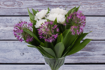 Bouquet of fresh flowers in vase. White and purple flowers on wooden background. Beauty of blossom.