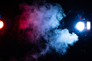 red blue and white smoke cloud with stage lights on black background