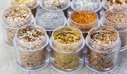 Golden silver Beautiful glitter close up in golden and silver tones in small glass jars, selective focusglitter