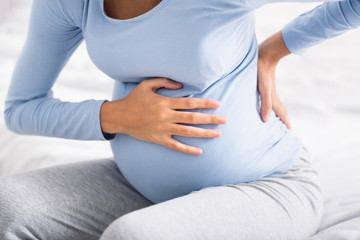 Pregnant woman having abdominal and back aches