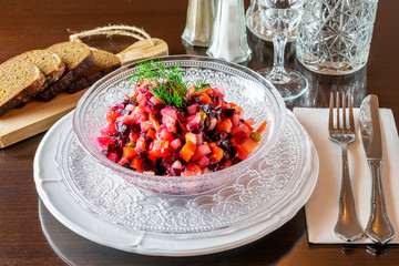 The vinaigrette of the various vegetables in the glass bowl on the table, served in the restaurant.