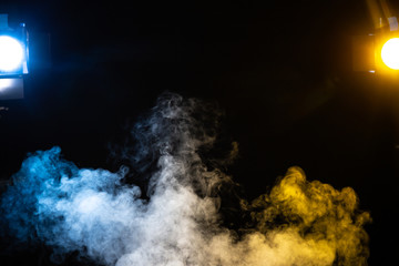 Blue white and yellow smoke on a black background with lights