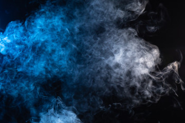Cloudy looking white and blue smoke on black background