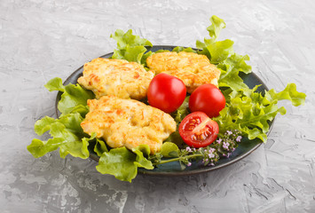 minced chicken cutlets with lettuce, tomatoes and herbs on a gray concrete background. side view.