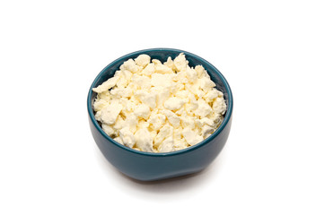 Fresh organic cottage cheese in blue ceramic bowl on a white background. Concept of healthy dairy products. Protein rich foods. Closeup. Copy space