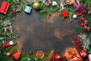 Christmas composition. Christmas gifts, pine branches, toys, deer, anise stars, santa hat on stone background with free space. Flat lay, top view.