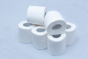 White toilet paper on white background. A few rolls.