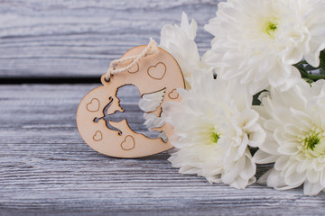 Valentines holiday flowers and wooden heart. Romantic gift for Valentines Day. Holiday greeting background.