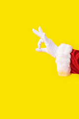 Santa Claus glove hand yellow background one red suit copy space