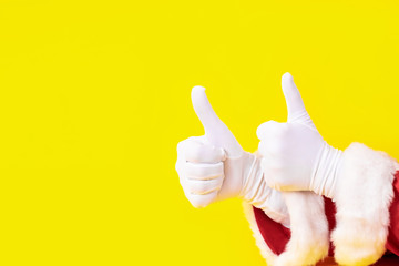 Santa Claus glove hand yellow background two red suit copy space