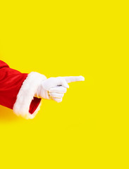Santa Claus glove hand yellow background one red suit copy space